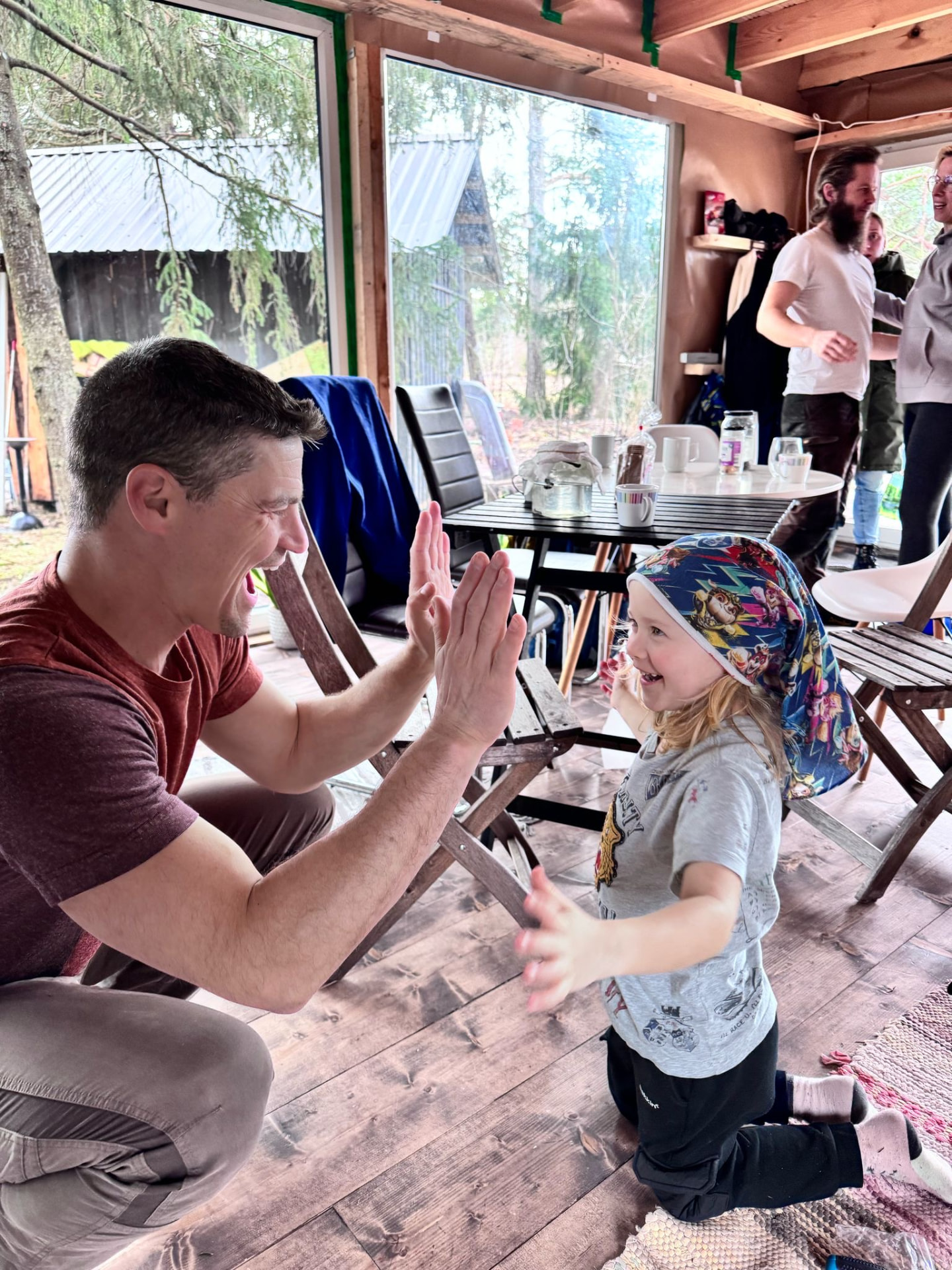 A guest and a child high-fiving in the doorway of an Estonian country house